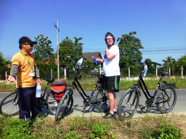 Chiang Mai Stefan with bicycle at street curb with tour guide