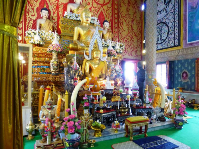 Thailand Chiang Mai god statue with gifts and flowers